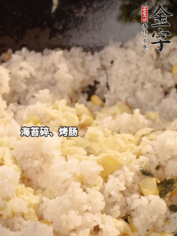 剩米飯下鍋炒散，依次下玉米粒、雞蛋、烤腸、海苔碎翻炒均勻。